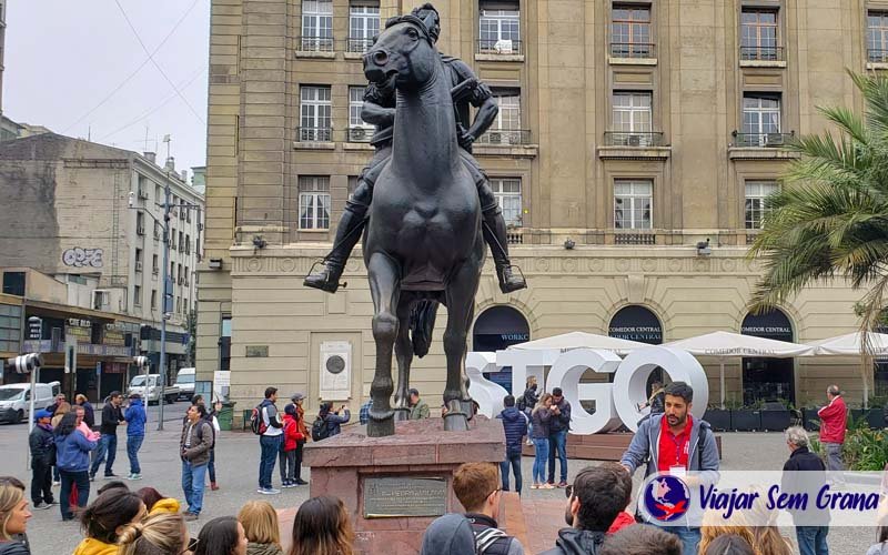 Guia ao lado de um monumento falando sobre a história de Santiago