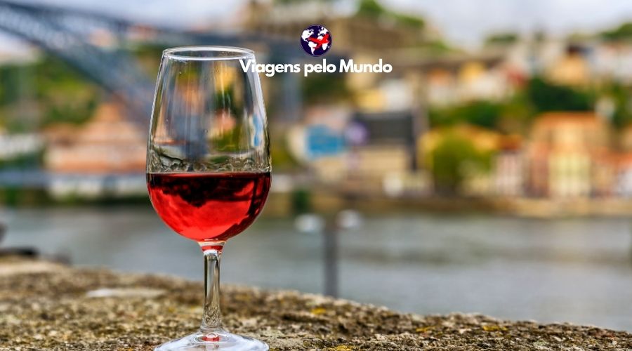 Vinícolas no Porto: Taça de vinho do Porto na mureta com vista para Porto