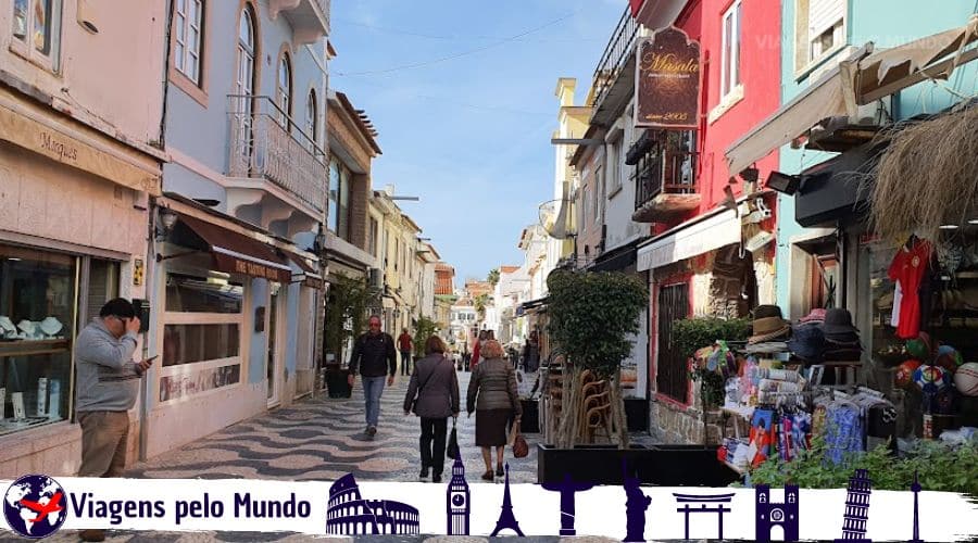 Centro Histórico de Cascais. Rua estreita em pedras que formam ondas e com lojas, restaurantes, cafés e bares.