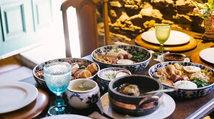 Restaurante Conto de Réis. Mesa grande com uma feijoada completa