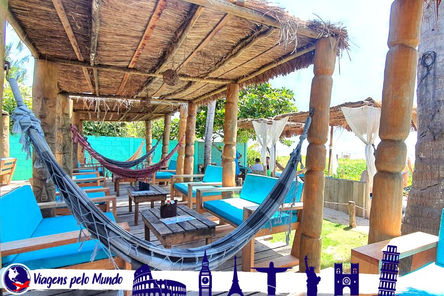 Gazebo do Beach Club Milagres do Toque. Espaço feito com palha, redes para descansar, espreguiçadeiras e vista para o mar de São Miguel dos Milagres