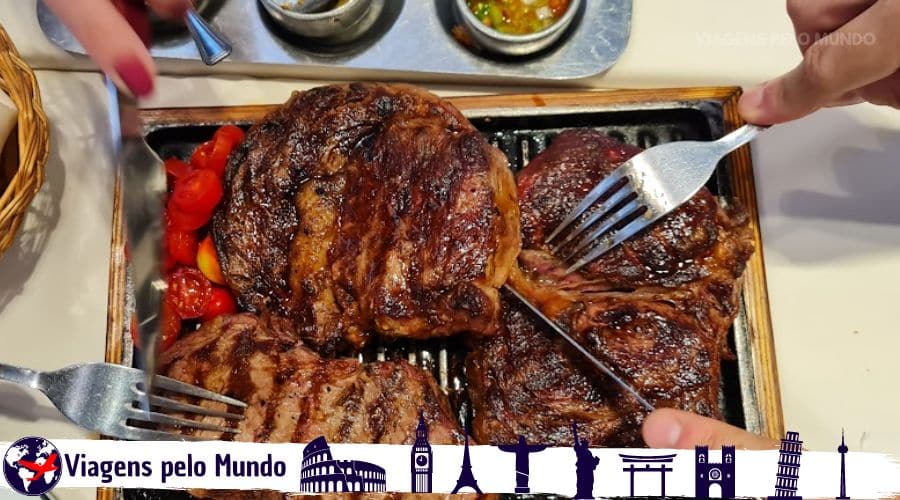 Cortes de carnes servidos em uma chapa de ferro. Ojo de Bife e Bife de Chorizo