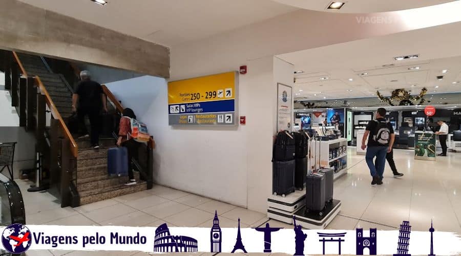 Escada com placa com indicação para Sala VIP e portões de embarque.