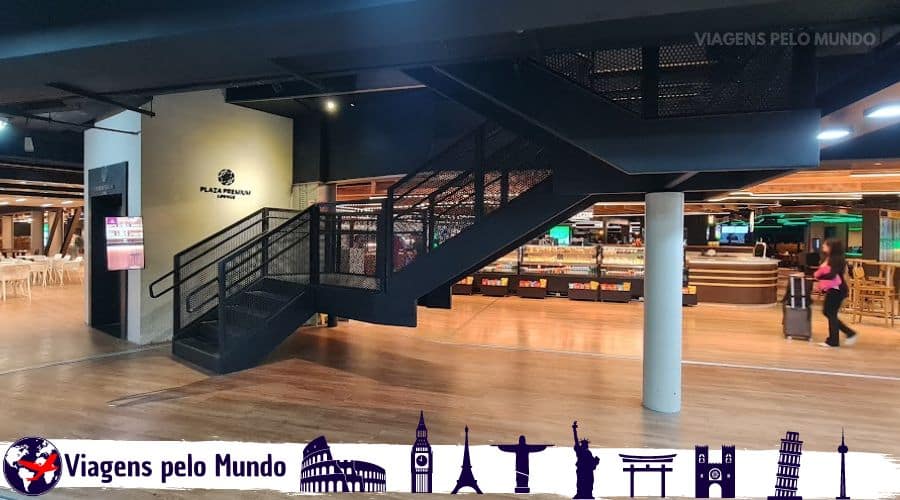 Entrada da Plaza Premium Lounge em Guarulhos. Uma escada preta e um elevador para acesso.