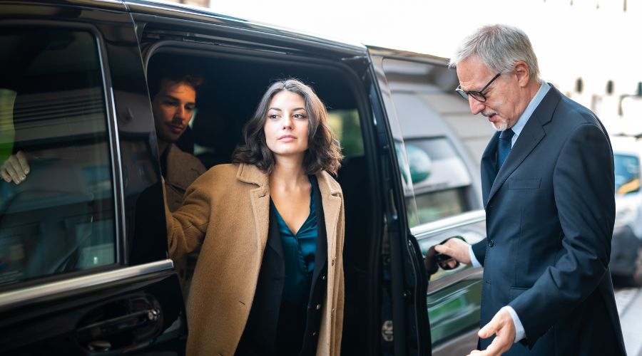 Transfer privado para sair do Aeroporto de Santiago. Casal chegando no hotel saindo da van e o motorista abrindo a porta