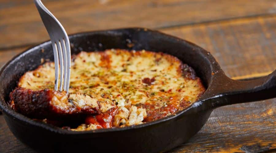 Panela de ferra com queijo derretido que forma a provoleta