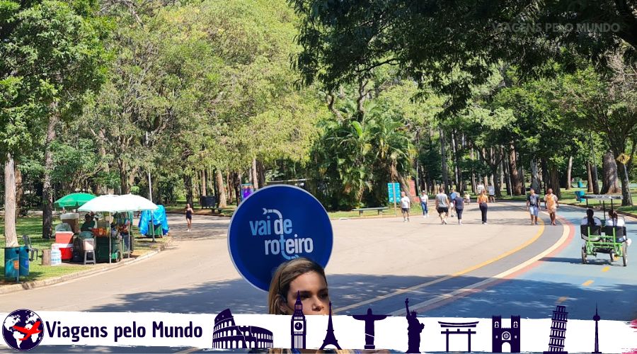 Tour Vai de Roteiro em SP. Guia com a placa com o nome Vai de Roteiro no parque do ibirapuera