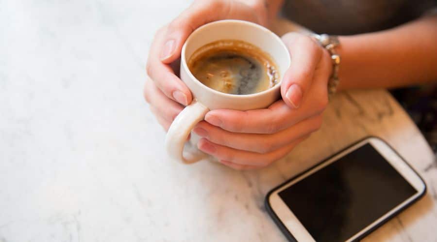 Mulher com uma xícara de café na mão