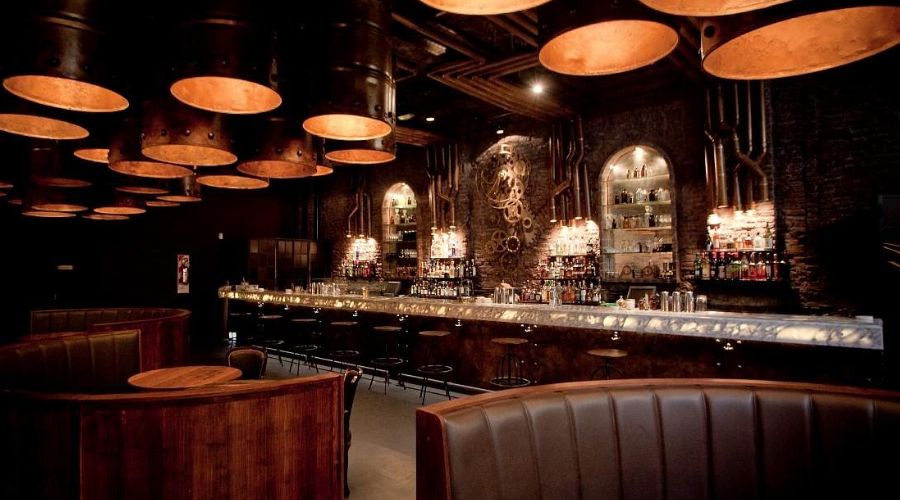 Interior do Victoria Brown Bar com decoração industrial e temática inspirada nas destilarias históricas.