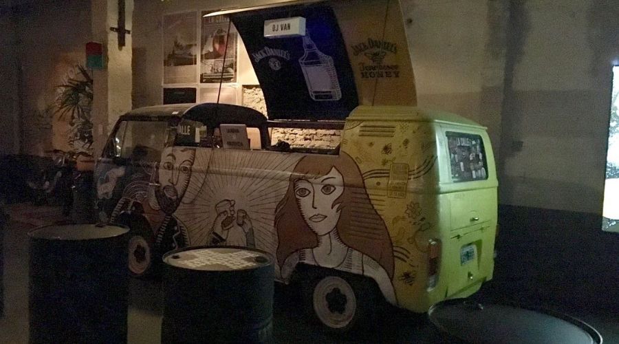 Interior do La Calle Bar com postes, grafites e calçadas simulando ruas de diferentes cidades.