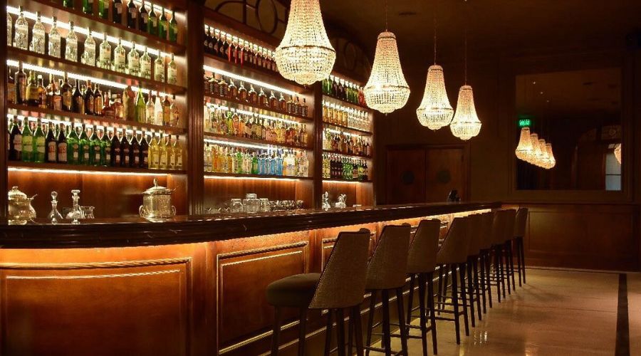 Interior do Presidente Bar, com decoração elegante e bartenders preparando coquetéis de alta classe.