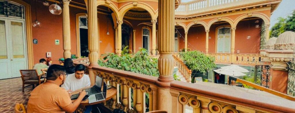 Varanda do Viajero Hostel em Lima com duas pessoas trabalhando com o notebook aberto