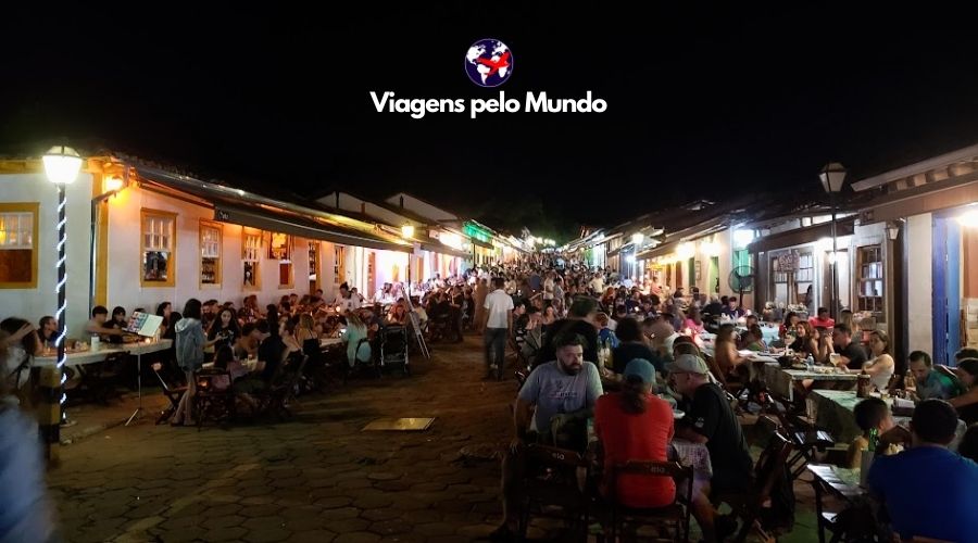 Rua do Lazer à noite. Cheia de mesas e turistas andando pela rua