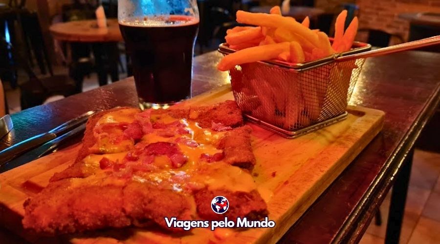 Milanesa que a gente provou no Uruguai acompanhada de batata frita e cerveja.